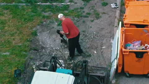 Man with a Shovel Loads Garbage Into a Tractor Tank Stock Footage 197548963