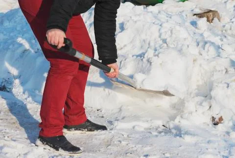 Man shoveling snow close up. Man cleaning snow from sidewalk in front of hous Stock Photos