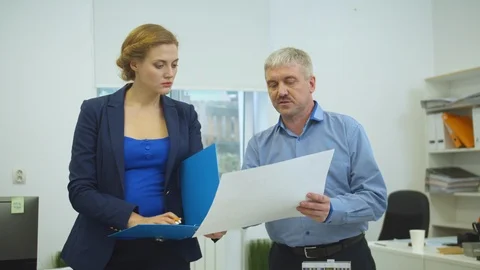 Man show document to woman with documents in her hands Stock Footage 121804991
