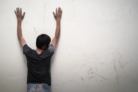 Man show hands up facing the wall Stock-Fotos