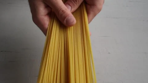 Man show raw spaghetti. Spaghetti in hands Video stock 143256458
