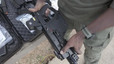 Man showing a Arma Kriss vector submachine gun, taking the weapon up from a box Stock Footage 304321489