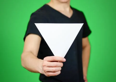Man showing blank white triangular flyer brochure booklet. Leaflet presenta.. Fotos Stock