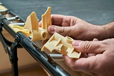 Man showing broken plastic bed slat holders Foto stock