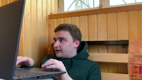Man showing different emotions while playing video games on his gaming laptop Stockbeeldmateriaal 194177478