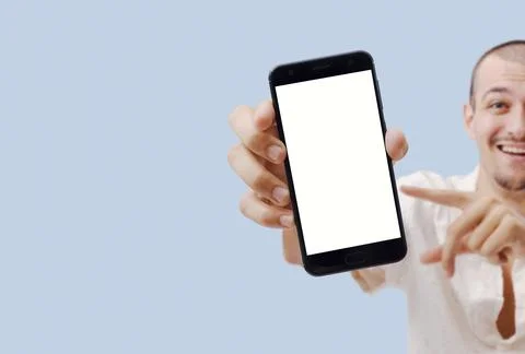 Man Showing Empty Smartphone Screen, Pointing with Finger, Blue Background Stock Photos