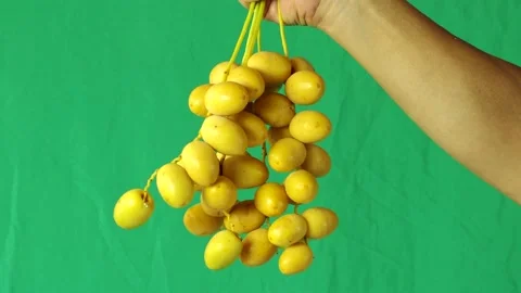 Man is showing  fresh dates, with green background . Stock Footage 202560694