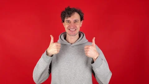 Man showing in front thumb up hand sign like gesture, looking smiling camera. 動画素材 304745945