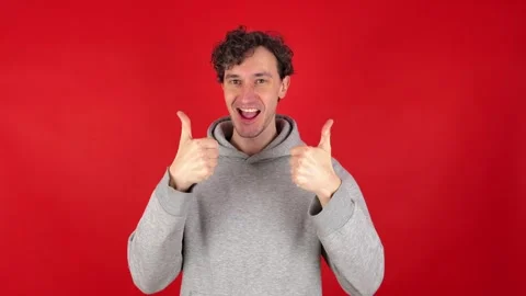 Man showing in front thumb up hand sign like gesture, looking smiling at camera. Stockbeeldmateriaal 304746038