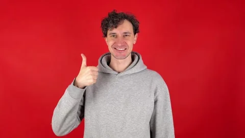 Man showing in front thumb up hand sign like gesture, looking smiling at camera. Stockbeeldmateriaal 304748210