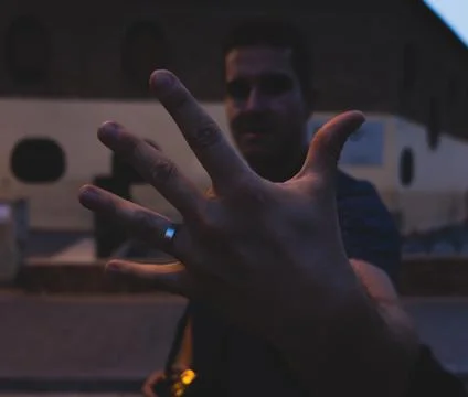 Man showing hand with ring with blurred face Stock Photos