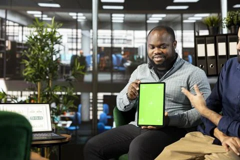Man showing isolated screen tablet to employees, presenting them data Stock Photos