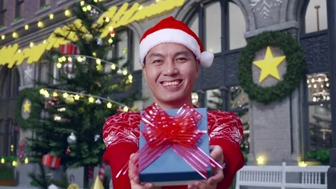 Man Showing A Present And Smiling To The Camera In Christmas Night Stock Footage 278410867