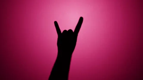 Man showing rock and roll gesture with fingers isolated on pink background. Male Stock Footage 170735341