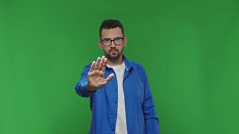 Man showing stop hand gesture or high five hand sign. Portrait isolated on green Stock Footage 171576306