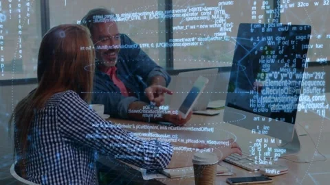 Man showing tablet and pointing, woman pausing typing following animated code Stock Footage 334316120