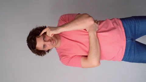 Man showing thinking gesture touching head by finger on gray background. Video stock 311874675