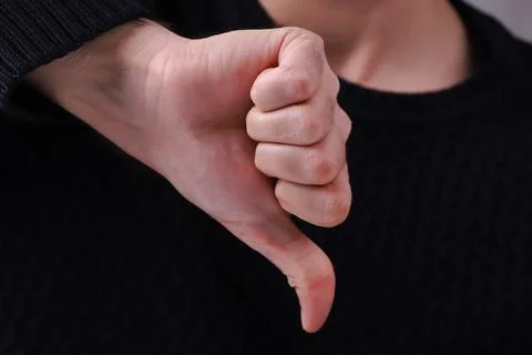 Man showing thumbs down. Negative concept. Close-up of young man's hands show Stock Photos
