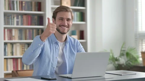 Man Showing Thumbs Up Sign While using Laptop at Work Video stock 162323414
