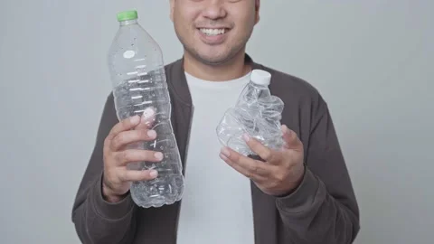 A man showing a used plastic bottle he will be recycled. World environment day.4 Stock Footage 145177167