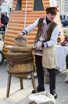 Man is showing work of old hand-mill during Shrovetide Stock Photos