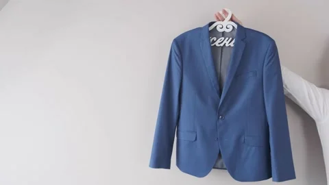 A man shows a blue jacket on a hanger Stock Footage 162479355