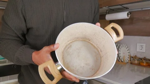 Man shows a cooking pot in a kitchen with modern design and features Stock Footage 346270314