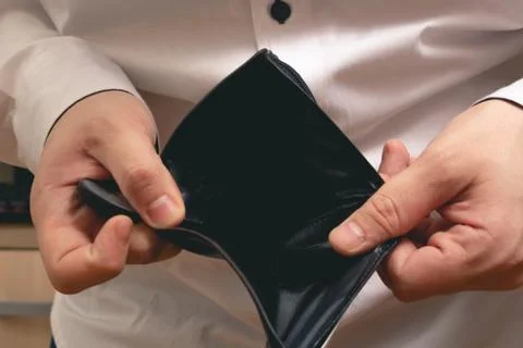 Man shows an empty wallet in a white shirt in the office Stock Photos