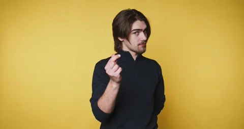 Man shows hand gestures in front of yellow background in short clips at dif.. Vídeo Stock 328249932