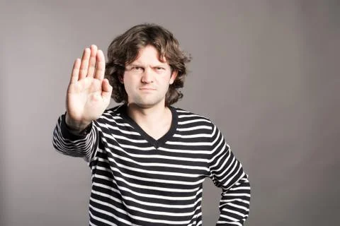 A man shows the hands stop timeout. Male in black and white sweater showing Stock Photos