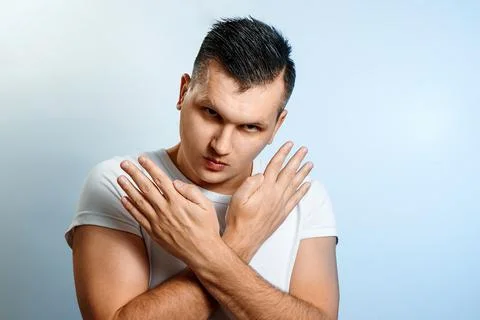 A man shows the hands stop timeout, fingers X. On a gray background. Stock Photos
