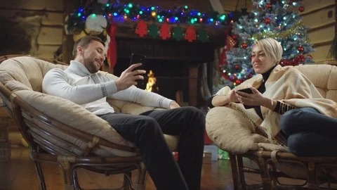 Man shows his smartphone screen to woman in Christmas night Video stock 100144086