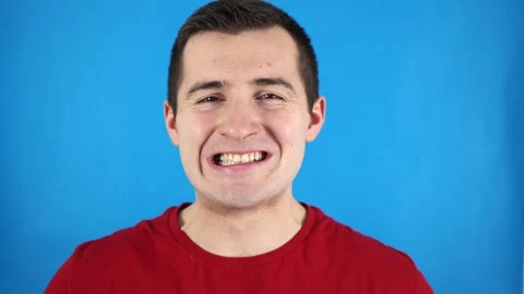 Man shows his teeth on a blue background Video stock 167333074
