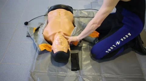 Man shows how to check pulse on dummy in the Training Center Video stock 65183147