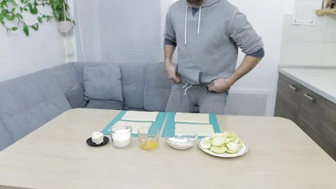 A man shows the ingredients for baking an apple pie on his own at home 動画素材 169699480