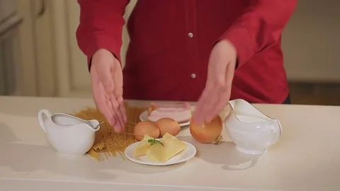 The man shows the ingredients in the kitchen, from which he will prepare pasta Stock Footage 81158649