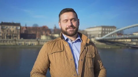 Man shows ok to camera on the background of the river and footbridge 库存影片 72709373