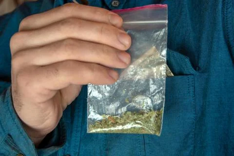 Man shows a packet with a spice inside Stock Photos