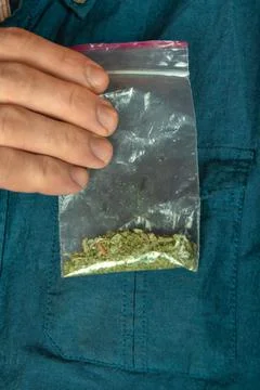 Man shows a packet with a spice inside Stock Photos