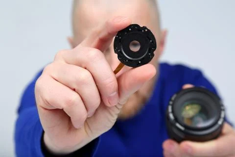 Man shows part of the diaphragm of the camera lens Stock Photos