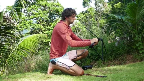 A man shows the process of assembling a folding ultra-light travel table Stock Footage 293755303