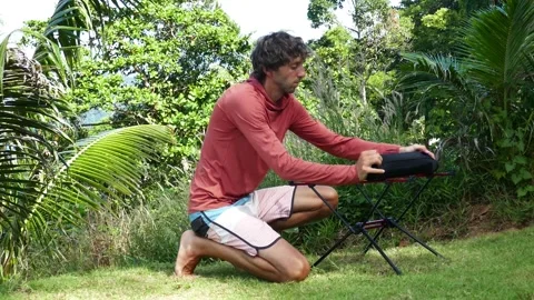 A man shows the process of disassembling a folding ultra-light travel table Stock Footage 293755311