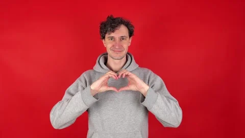 Man shows shape of heart frame with two hands in front Видео 304746984