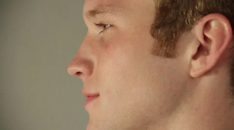 Man shows a side view and smiles in front of camera Stock Footage 22844052