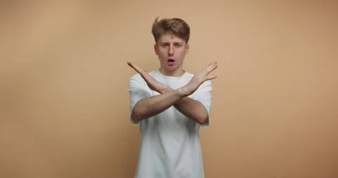 Man shows stop gesture with hands in four frames in indoor location during .. Vídeos de archivo 328247137