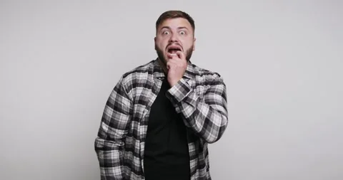 Man shows surprise expression with his hands on his face in studio setting Vidéo 326798365