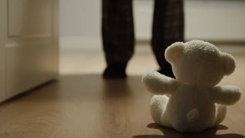 Man Shuts A Door In Front Of Plush Bear Toy Leaving It Alone In A Dark Room Stock Footage 124623599