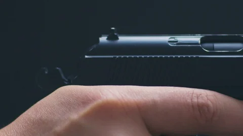 Man shutter cocking and shoots with air pistol on black background the gun ran Видео 128321937