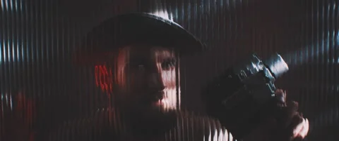 Man in shutter lights looking through clear panel with vintage camera Stock Footage 203571989