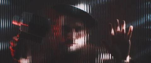 Man in shutter lights looking through clear panel with vintage camera Stock Footage 203572213